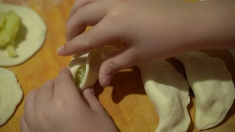 Close-up, the child makes dumplings, the boy sculpts dumplings from the dough Stock Footage 223715804