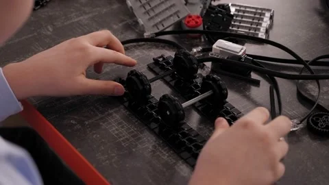 Close-up of child making robots from the constructor at the desk with computer. Stock Footage 150442271