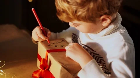 Close up child paints gift box New year present packaging. Making surprise fo Vídeo Stock 220580280