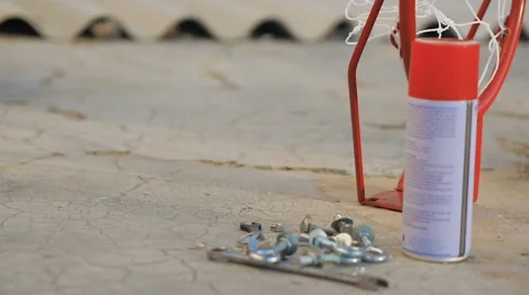 Close up: child picking up from floor can of paint to spray wooden board Stock Footage 61474877