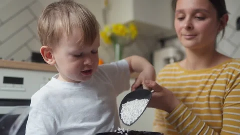 Close-up of child pouring perlite into a pot of soil for planting seedlings Stock Footage 331438519