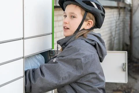 Close up of child taking parcel from locker system. 스톡 사진