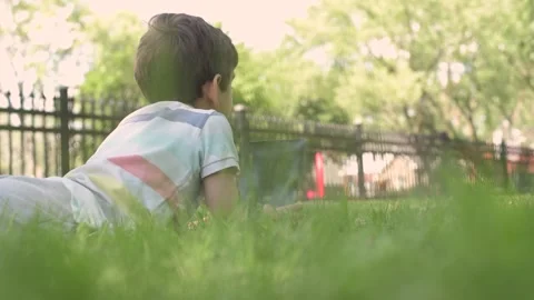 Close up Child using Digital Tablet sitting on the grass outdoors Stock Footage 204092971