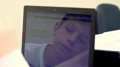 Close-up, a child working on a laptop. the face of the child is reflected in the Video stock 118846492