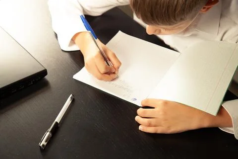 Close-up of a child writes in a notebook. Stock Photos