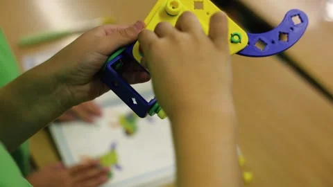 Close-up of children assembling colorful plastic construction parts, educational Stock Footage 318212119
