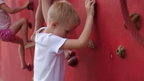 Close-up of children climbing a climbing wall in a modern park. Stock Footage 205811985
