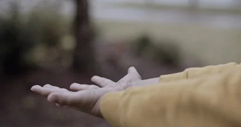 Close up of a children hands playing in the rain and getting his hands wet outsi Stock Footage 128841703