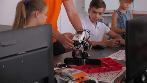 Close up children with a teacher assemble a robot at the school of robotics. Stock Footage 142077992