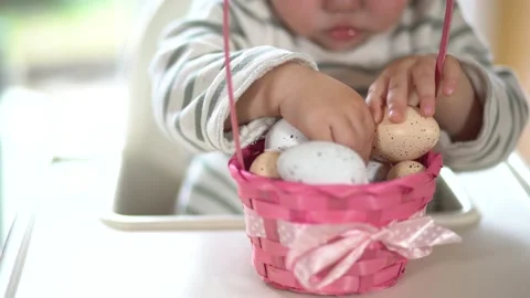 Close up of children's hands and Easter eggs in a basket. The child plays wi Stock Footage 235843650