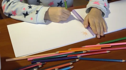 Close-up of children's hands, the child draws colored pencils on a white sheet. Stock Footage 101638639