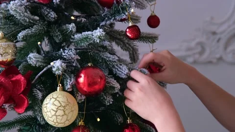 Close-up of children's hands. A child hangs a toy on a Christmas tree. Beautiful Stock Footage 220331459