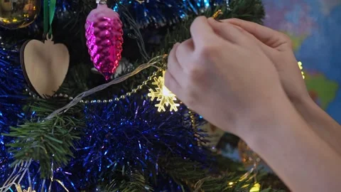 Close-up of children's hands decorating a Christmas tree with a deer toy against Stock Footage 166852990