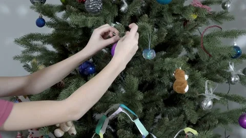 Close-up, children's hands hang colored toy balls on the Christmas tree. Stock Footage 141983291