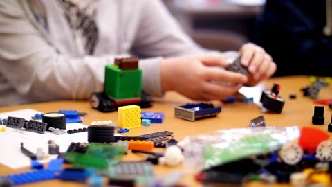 Close-up, children's hands hold a multicolored small robot, machine, assembled Stock Footage 89239028