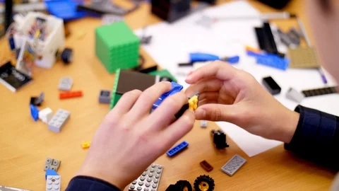 Close-up, children's hands hold a multicolored small robot, machine, assembled Video stock 89242200