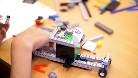 Close-up, children's hands hold a multicolored small robot, machine, assembled Stock Footage 89243279