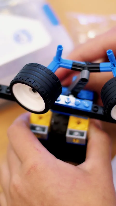 Close-up, children's hands hold a multicolored small robot, machine, assembled Stock Footage 316889620