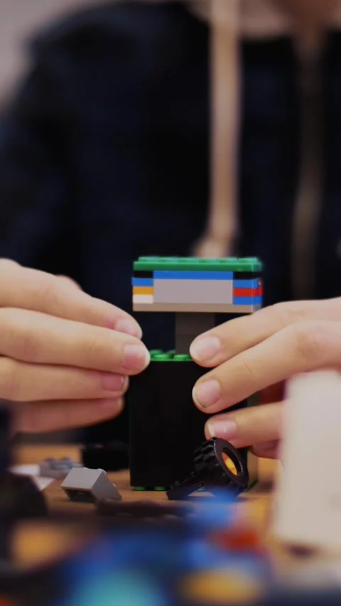 Close-up, children's hands hold a multicolored small robot, machine, assembled Stock Footage 316986151