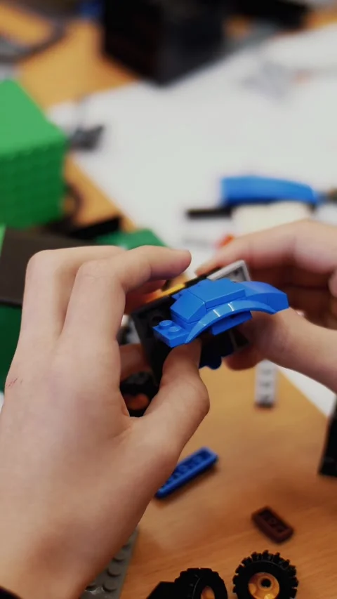 Close-up, children's hands hold a multicolored small robot, machine, assembled Video stock 317309662
