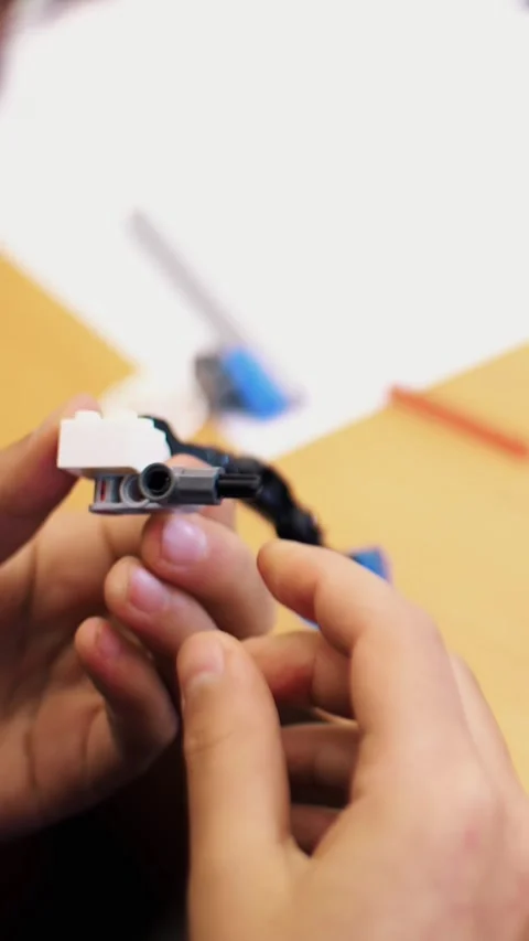 Close-up, children's hands hold a multicolored small robot, machine, assembled Video stock 317309747