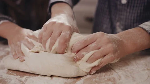 Close up of the children's hands kneading a dough on the wooden table covered Stock Footage 92837676