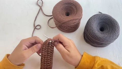 Close-up of children's hands learning to crochet from brown yarn Stock Footage 234242235