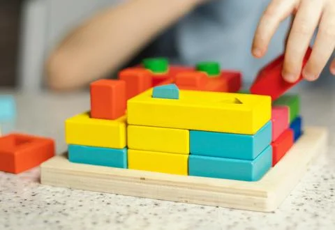 Close-up of children's hands playing with an educational multi-colored puzz.. Stock Photos