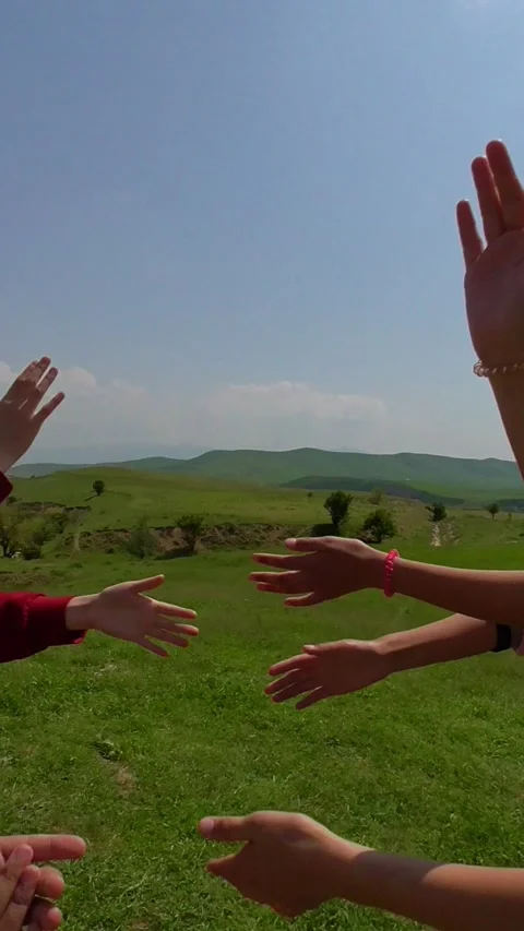 Close up of children's hands playing a game or reaching out to each other on a g Stock Footage 342059728