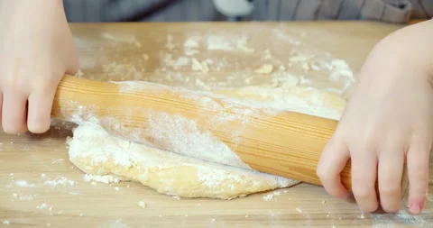 Close-up of children's hands rolling dough for cookies. Child helping mom Stock Footage 132747462