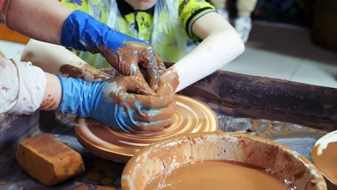 Close-up of children's hands sculpting ceramic dishes from clay in the workshop. Stock Footage 280435112