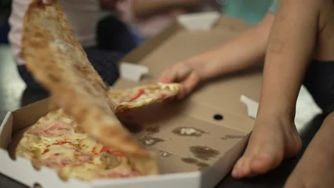 Close-up children's hands take a piece of pizza from the table. Stock Footage 221563592