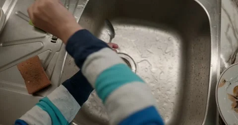 Close-up children's hands wash kitchen utensils sink and dishes. 4K  Stock Footage 345448218