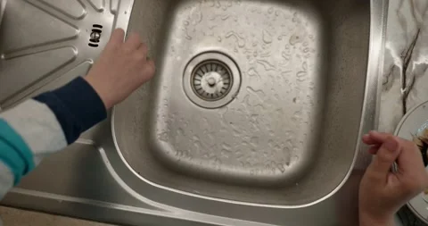 Close-up children's hands wash kitchen utensils sink and dishes. 4K  Stock Footage 345448255