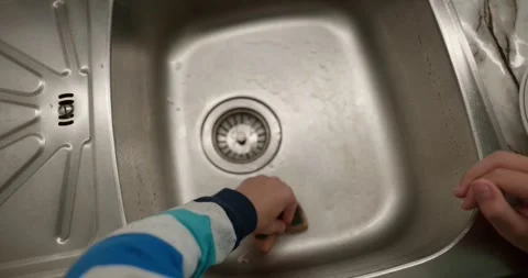 Close-up children's hands wash kitchen utensils sink and dishes. 4K  Stock Footage 345448258
