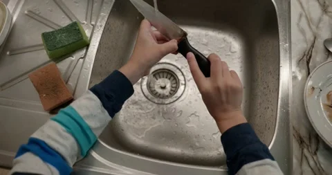 Close-up children's hands wash kitchen utensils sink and dishes. 4K  Stock Footage 345448267