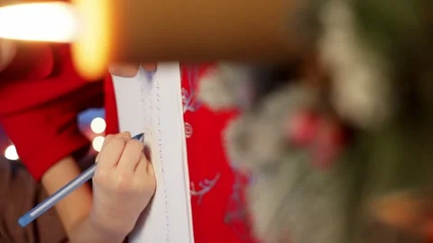 Close-up of children's hands writing a letter to Santa Claus on paper. Stock Footage 258358984