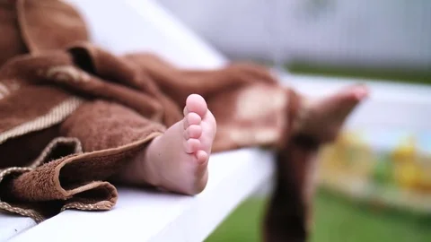 Close-up of children's legs, a little one-year-old girl wrapped in a towel Stock Footage 80441636