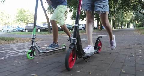 Close-up of children's legs on scooters. Stock Footage 94650967