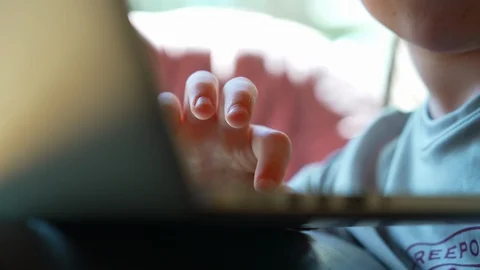 Close up of child’s hand on laptop  doing schoolwork at home Stock Footage 129641273