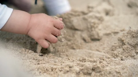 Close up on a child's hand - playing in the sand on a beach Stock-Footage 95936989