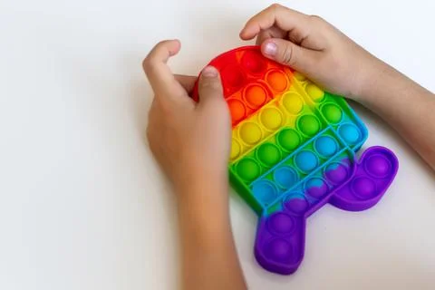 Close-up of a child's hand pushing a simple bubble antistrest toy pop it Stock Photos
