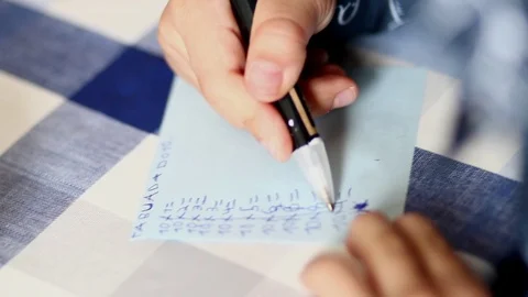 Close up of child´s hand scribbling maths with a pencil on a piece of Stock Footage 106555199