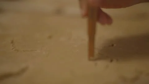 Close-up of child's hands drawing in dough with spatula Stockbeeldmateriaal 336374731