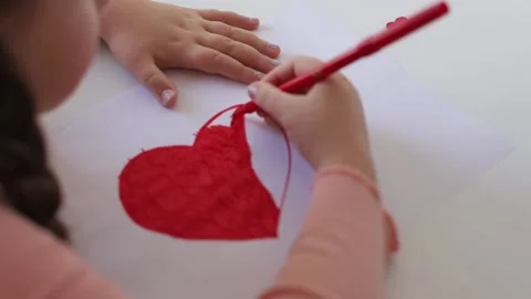Close up child's hands drawing a red heart on a light background. Stock Footage 231800831