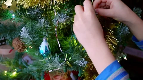 Close-up of child's hands hanginga red ball on Christmas tree. Stock Footage 247006571
