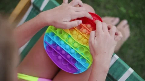 Close up child’s hands hold crumple a rubber toy popit. Pop It close up top view Stock Footage 241018068
