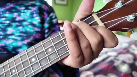 Close up of a child’s hands learning to play the ukulele Stock Footage 327081322