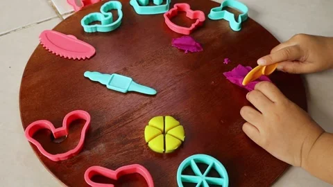 Close-up of a child's hands playing with colorful playdough and plastic molds. Stock Footage 345766664