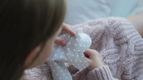 Close-up of a child's hands sewing a soft toy. Video stock 243259829